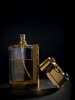 Sophisticated perfume bottle with gold details on a black backdrop, exuding luxury.